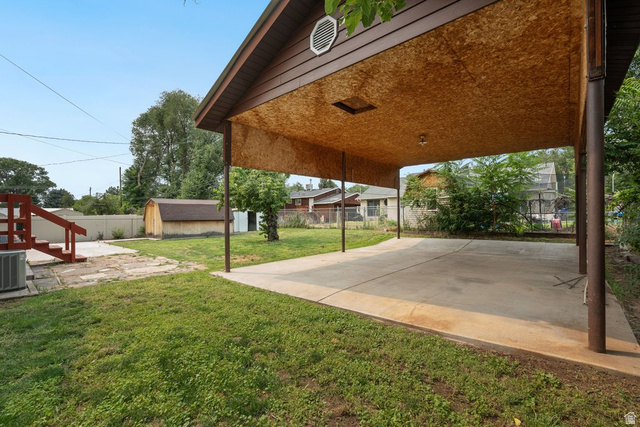 673 East 700 South Springville, UT 84663 - Photo 41 of 43 Expansive concrete carport with a wood-finish ceiling, supported by sturdy metal posts