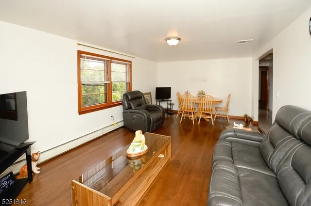 a living room with furniture and a flat screen tv with wooden floor