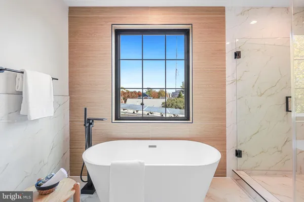 a white bath tub sitting in a bathroom next to a window