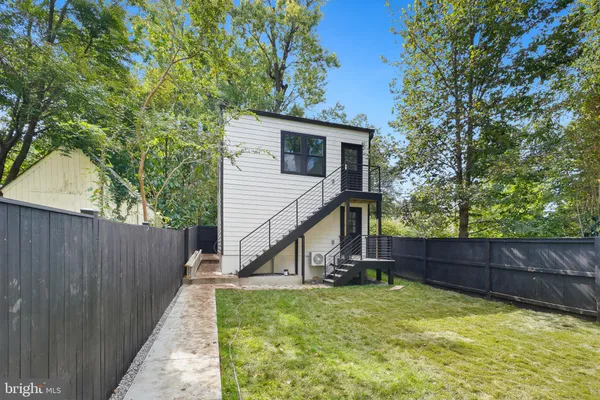 a view of backyard with small cabin and wooden fence
