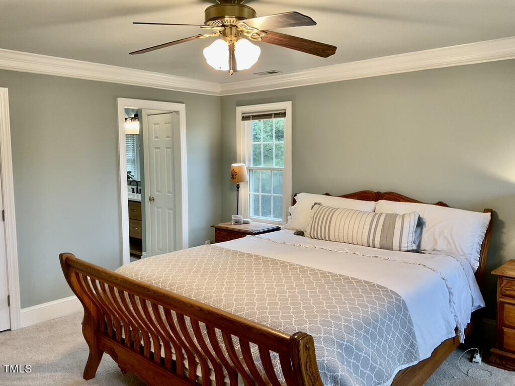 4209 Old Lewis Farm Road Raleigh, NC 27604 - Photo 15 of 47 a bedroom with a bed and a chandelier