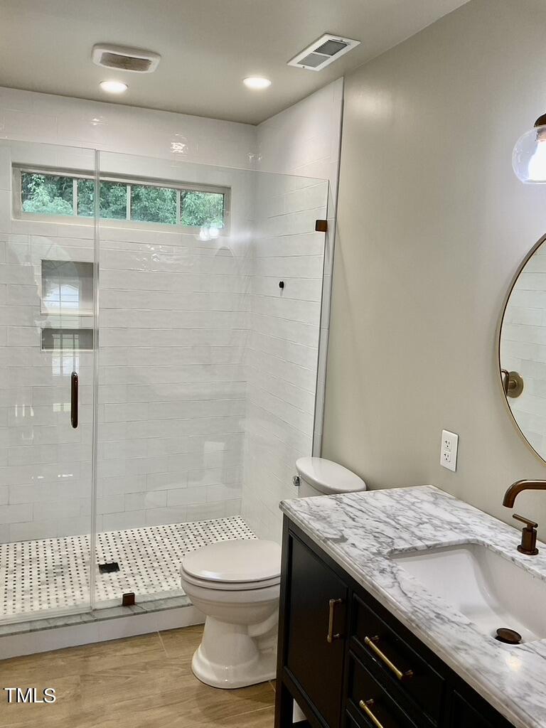 4209 Old Lewis Farm Road Raleigh, NC 27604 - Photo 17 of 47 a bathroom with a granite countertop sink a toilet a mirror and shower