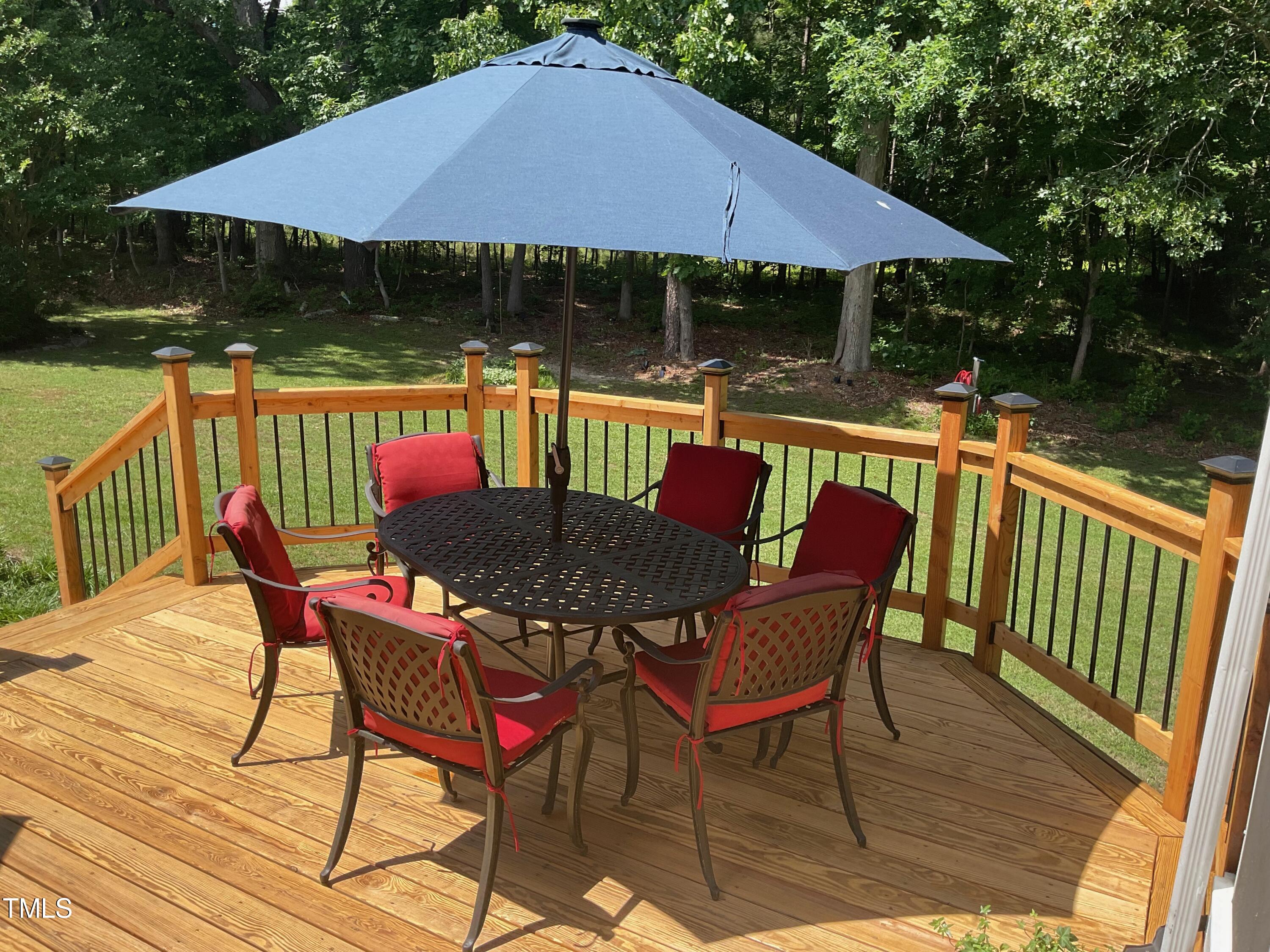4209 Old Lewis Farm Road Raleigh, NC 27604 - Photo 34 of 47 a patio with wooden floor a yard a yard a table and chairs