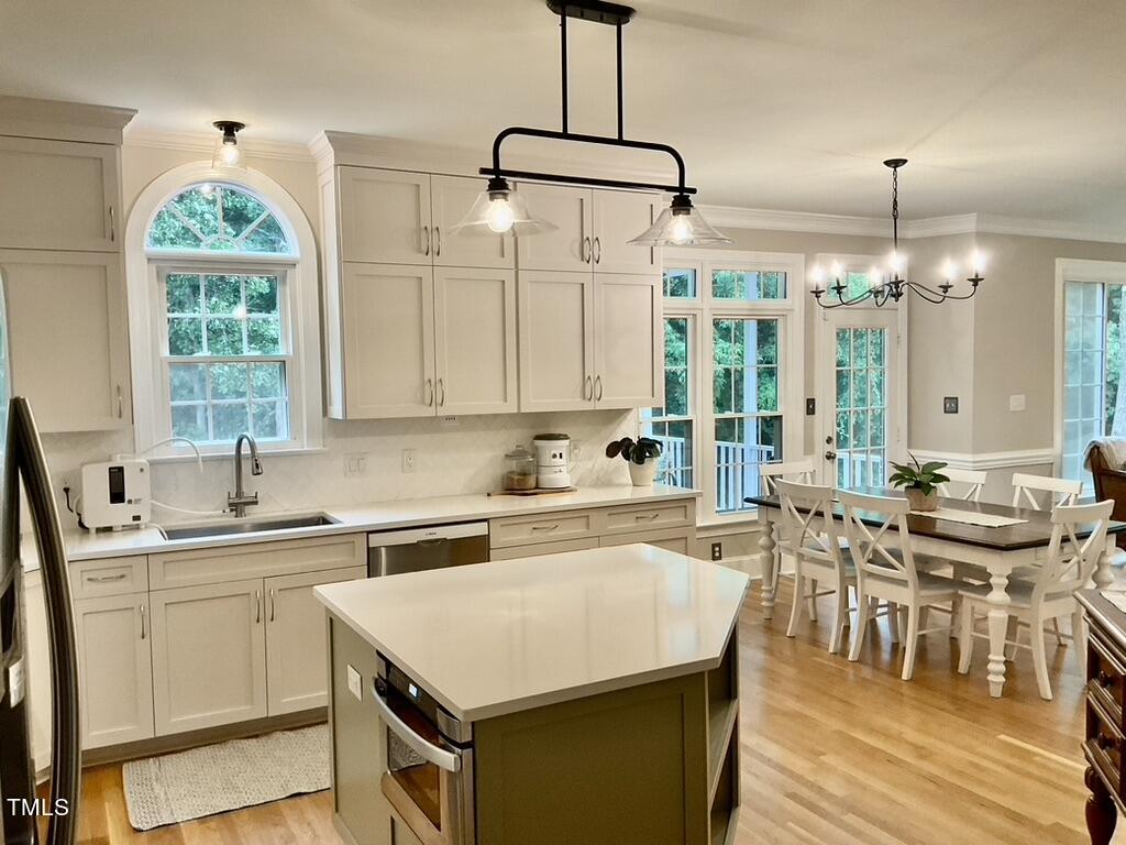 4209 Old Lewis Farm Road Raleigh, NC 27604 - Photo 4 of 47 a kitchen with a stove a sink a center island and windows