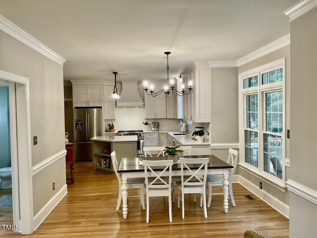4209 Old Lewis Farm Road Raleigh, NC 27604 - Photo 5 of 47 a view of a dining room with furniture a chandelier and wooden floor