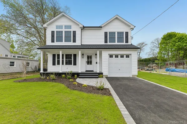 a front view of a house with yard and green space