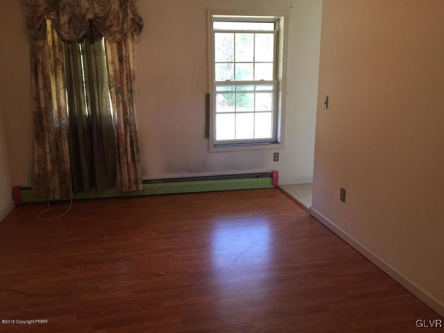 5644 Neola Road Stroudsburg, PA 18360 - Photo 4 of 24 an empty room with wooden floor and windows