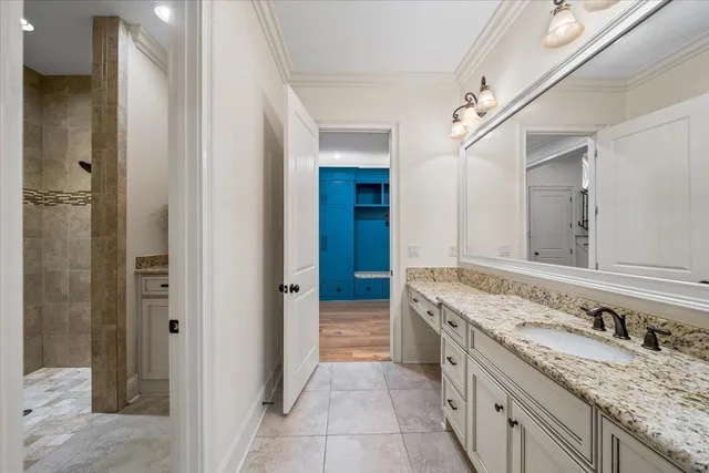 a bathroom with a granite countertop double vanity sink and a mirror