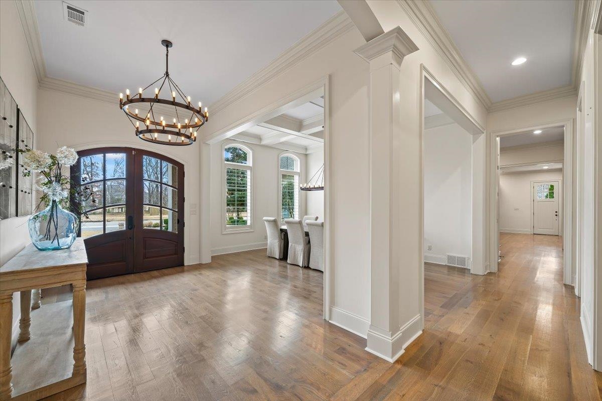 547 Lambs Brook Lane Collierville, TN 38017 - Photo 7 of 40 a view of a hallway with wooden floor and a chandelier