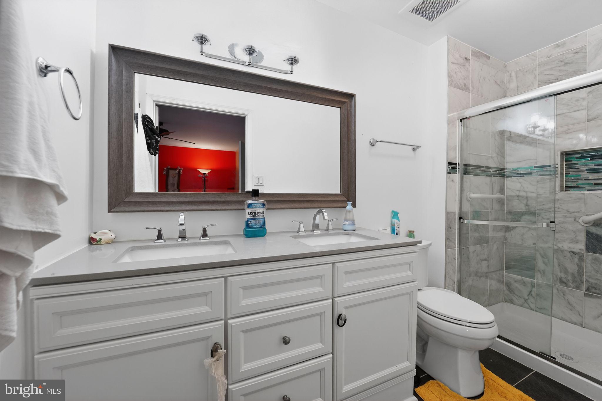 9214 Three Oaks Drive Silver Spring, MD 20901 - Photo 12 of 14 a bathroom with a toilet sink and mirror