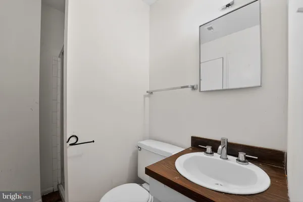 a bathroom with a sink mirror and toilet