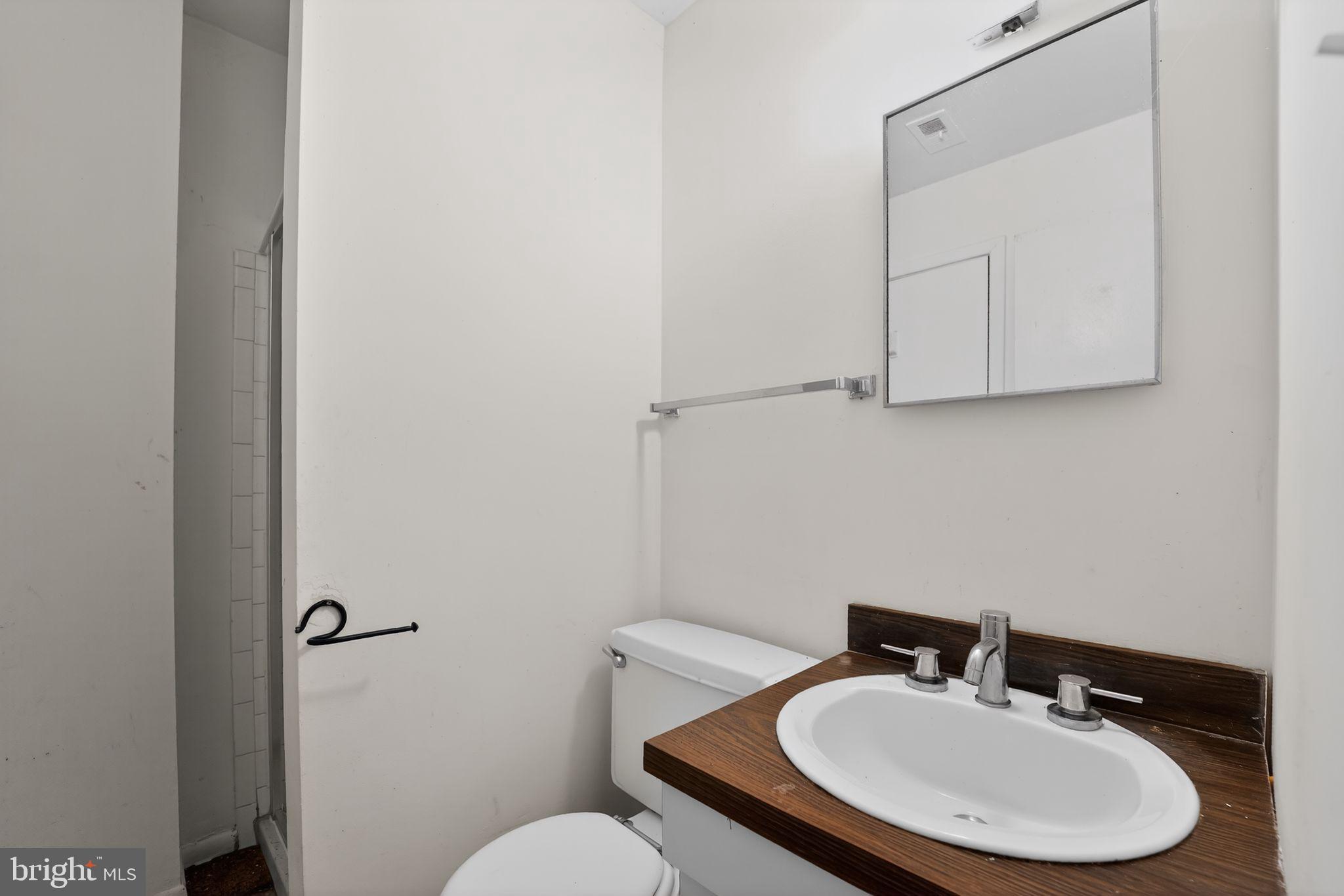 9214 Three Oaks Drive Silver Spring, MD 20901 - Photo 13 of 14 a bathroom with a sink mirror and toilet