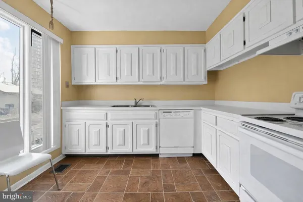 a kitchen with granite countertop white cabinets and stainless steel appliances