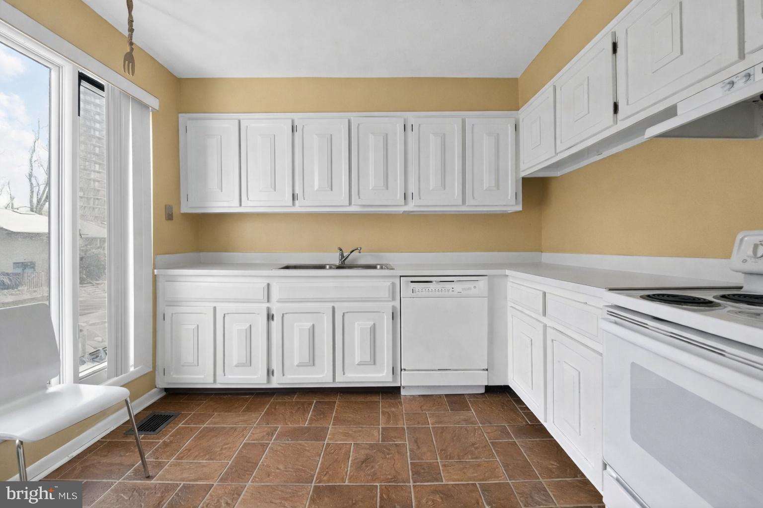 9214 Three Oaks Drive Silver Spring, MD 20901 - Photo 4 of 14 a kitchen with granite countertop white cabinets and stainless steel appliances