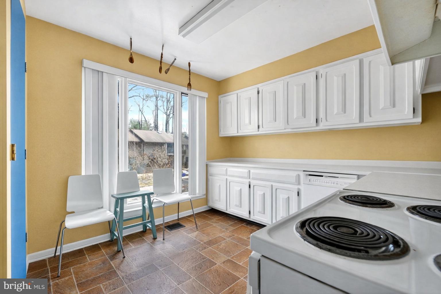 9214 Three Oaks Drive Silver Spring, MD 20901 - Photo 5 of 14 a kitchen with a sink a stove and white cabinets