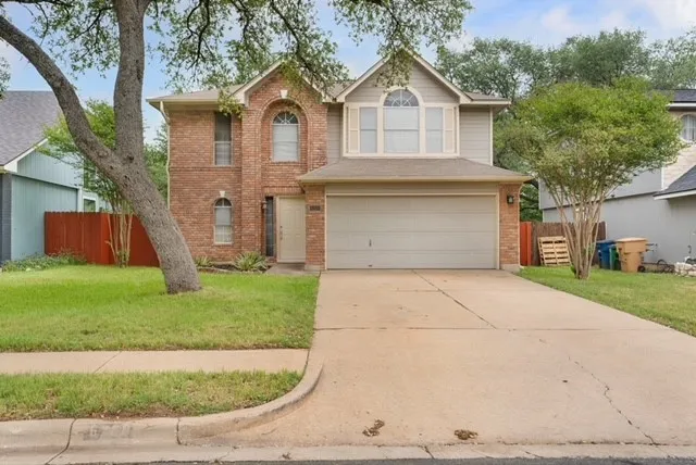 a front view of a house with a yard and a garage