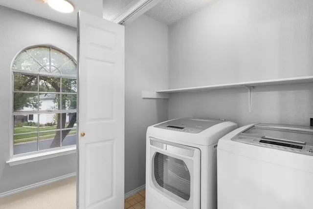 a view of a white house with a large tree and a yard