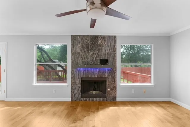 an empty room with windows and fireplace