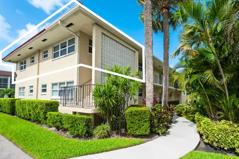 a front view of a house with plants and entryway