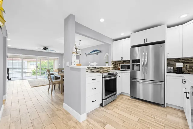 a kitchen with white cabinets and stainless steel appliances