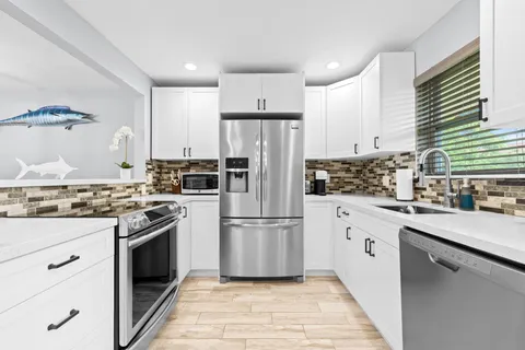a kitchen with stainless steel appliances granite countertop a stove a refrigerator and a refrigerator