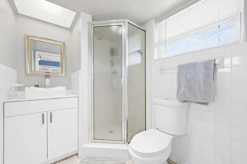 a bathroom with a sink a toilet and shower