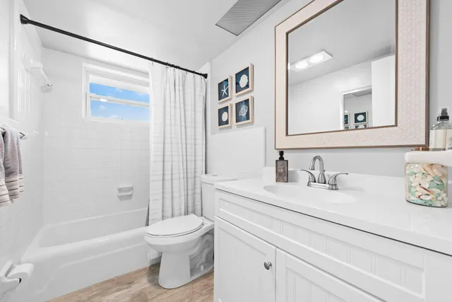 a bathroom with a granite countertop sink toilet a mirror and shower