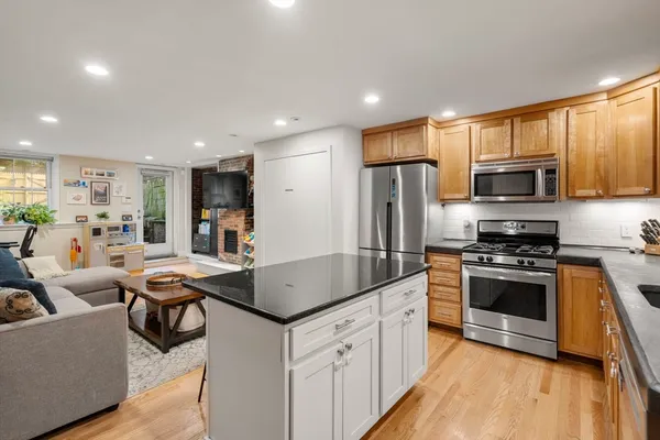 a kitchen with stainless steel appliances granite countertop a stove refrigerator and a microwave
