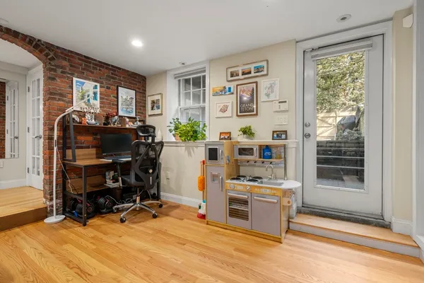 a view of a workspace with furniture and a window