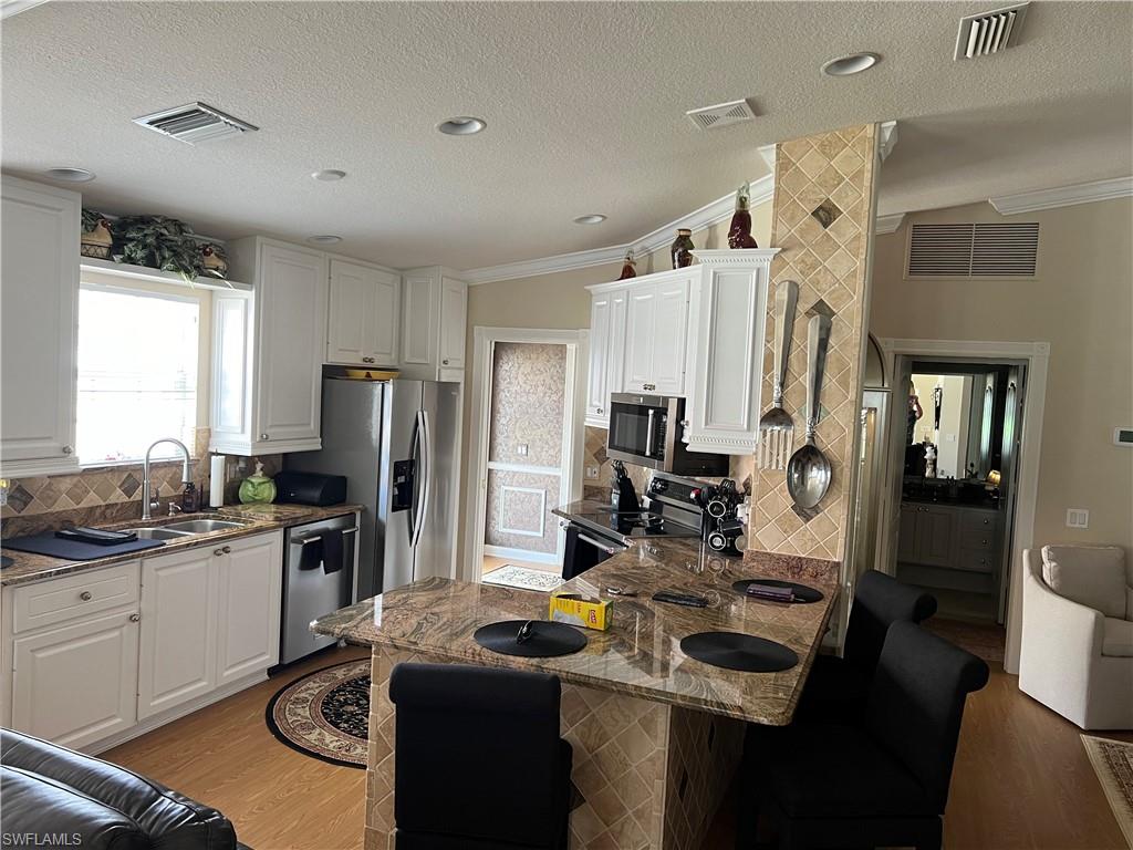 5433 Guadeloupe Way Naples, FL 34119 - Photo 5 of 16 a kitchen with a sink stove and refrigerator