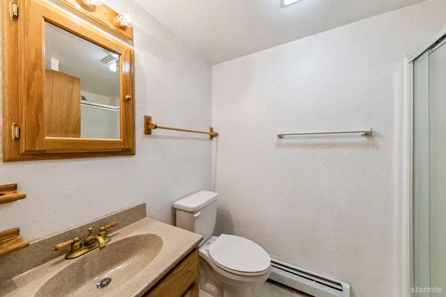 a bathroom with a sink a toilet and mirror
