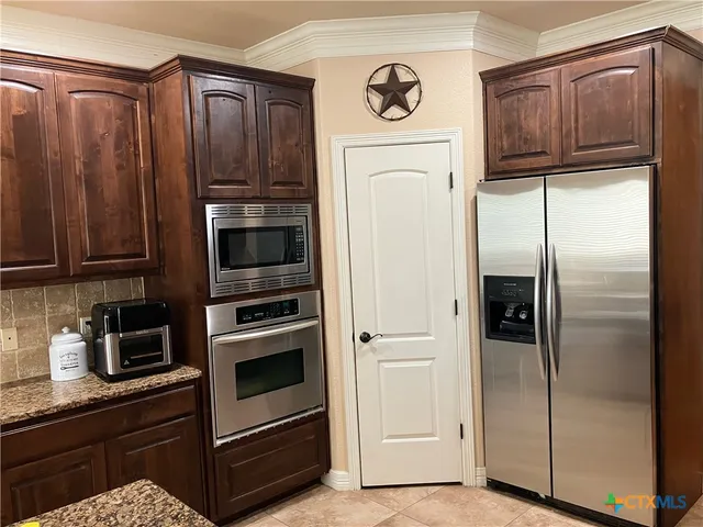 a kitchen with stainless steel appliances granite countertop a refrigerator and a stove