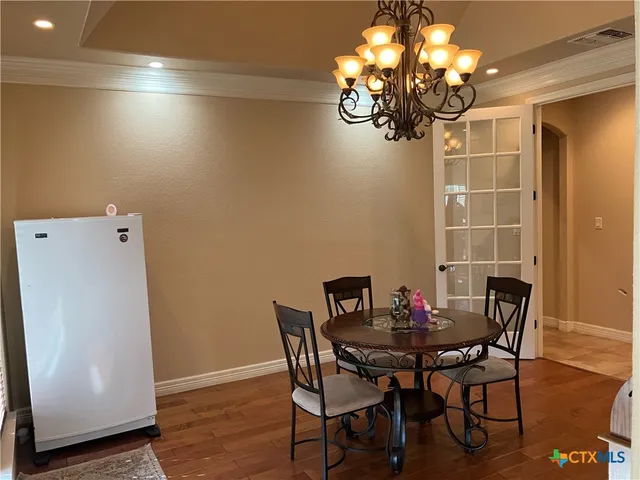 a view of a dining room with furniture and chandelier