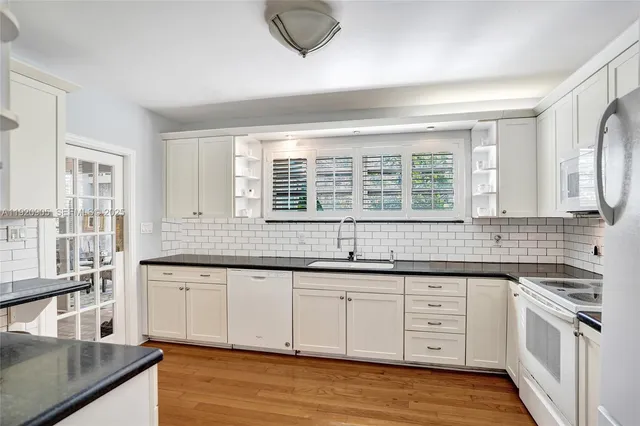 a kitchen with stainless steel appliances granite countertop a stove and a sink