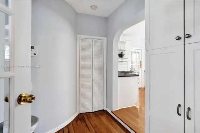 a view of a hallway with wooden floor and closet area