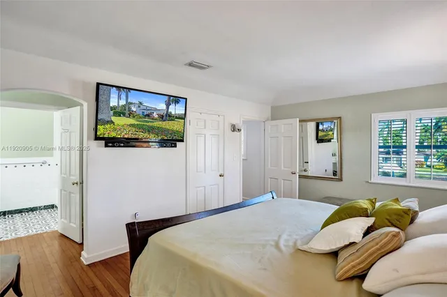 a bedroom with a bed and a flat screen tv