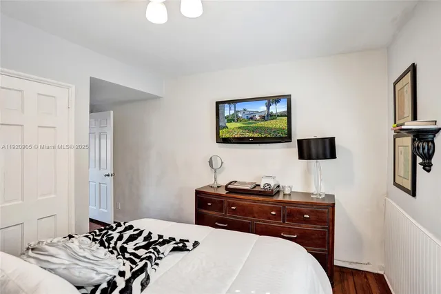 a bedroom with a bed and a flat screen tv