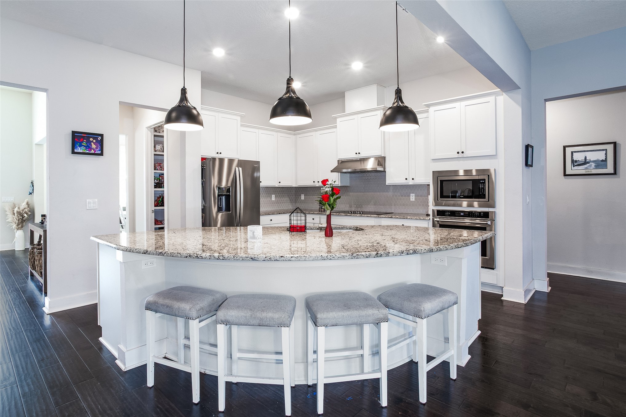 a kitchen with stainless steel appliances kitchen island granite countertop a dining table chairs and sink