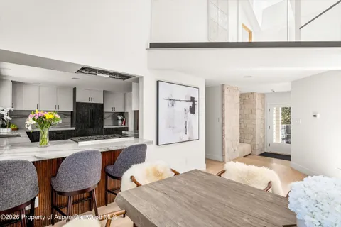 a kitchen with a table chairs refrigerator and microwave