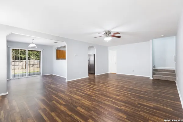 a view of an empty room with window and wooden floor