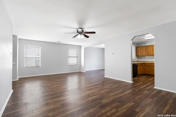 a view of a livingroom with wooden floor and a ceiling fan