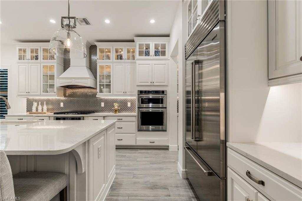 3664 Pilot Circle Naples, FL 34120 - Photo 14 of 35 a kitchen with stainless steel appliances granite countertop a stove and a refrigerator