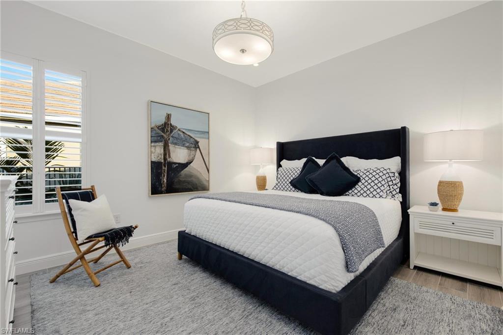 3664 Pilot Circle Naples, FL 34120 - Photo 21 of 35 a bedroom with bed and a chandelier