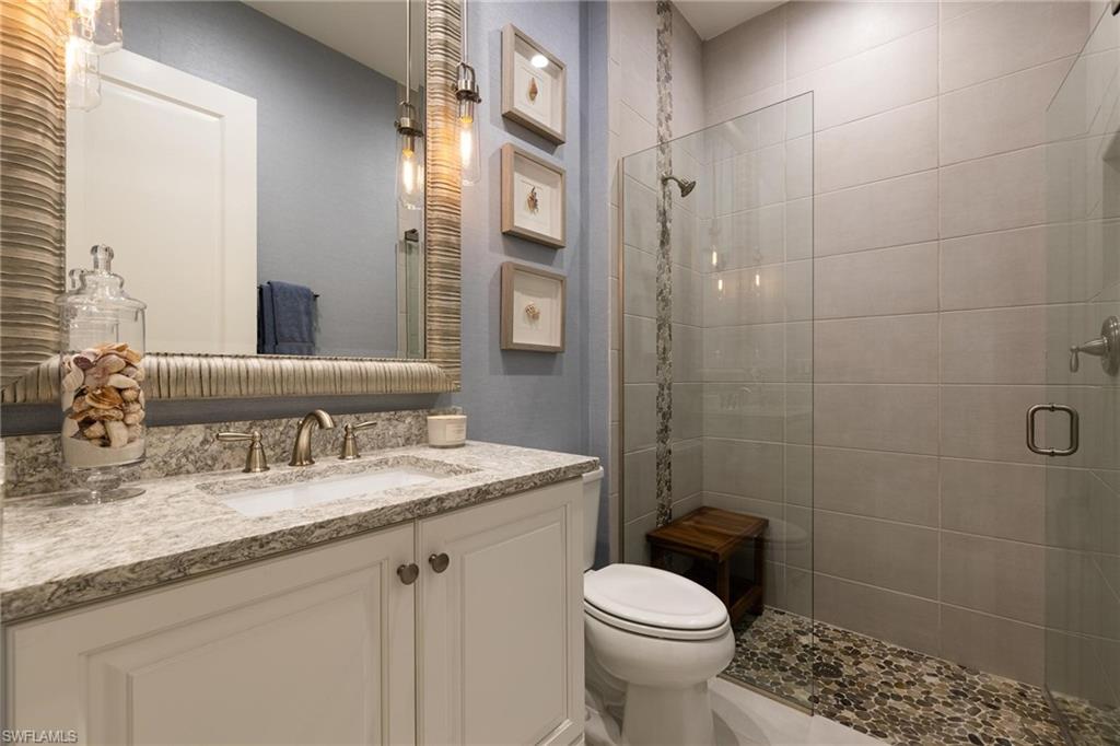 3664 Pilot Circle Naples, FL 34120 - Photo 22 of 35 a bathroom with a granite countertop sink toilet and shower