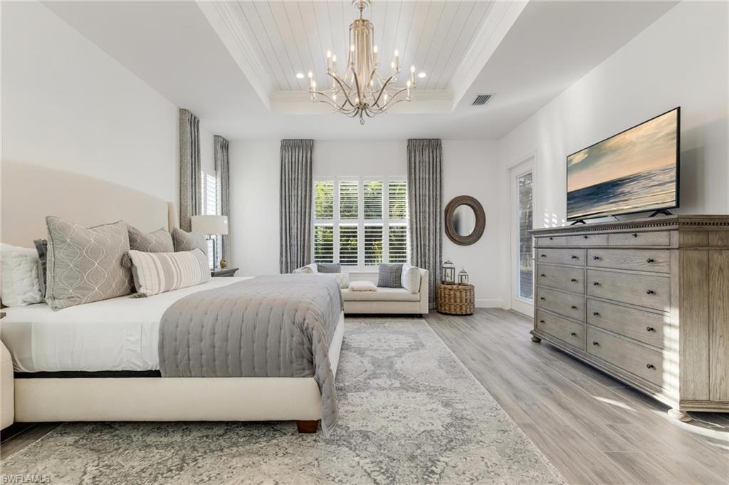 3664 Pilot Circle Naples, FL 34120 - Photo 27 of 35 a bedroom with a large bed and a flat tv screen on dresser