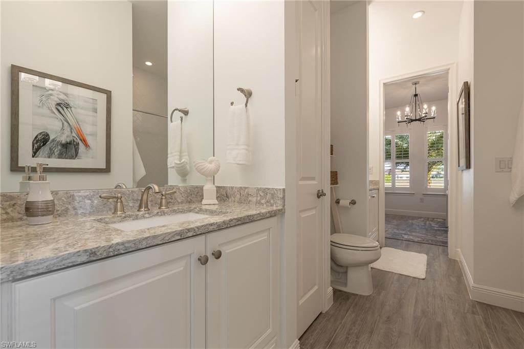 3664 Pilot Circle Naples, FL 34120 - Photo 5 of 35 a bathroom with a granite countertop sink a toilet and shower