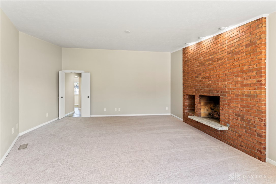 2247 East Whipp Road Dayton, OH 45440 - Photo 14 of 52 This expansive living area features a prominent brick fireplace, perfect for cozy gatherings.