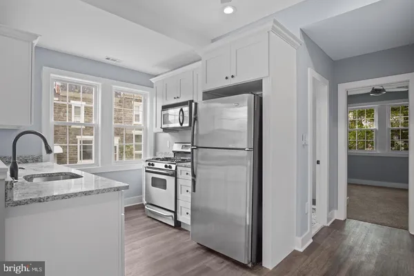 a kitchen with appliances a sink cabinets and a window