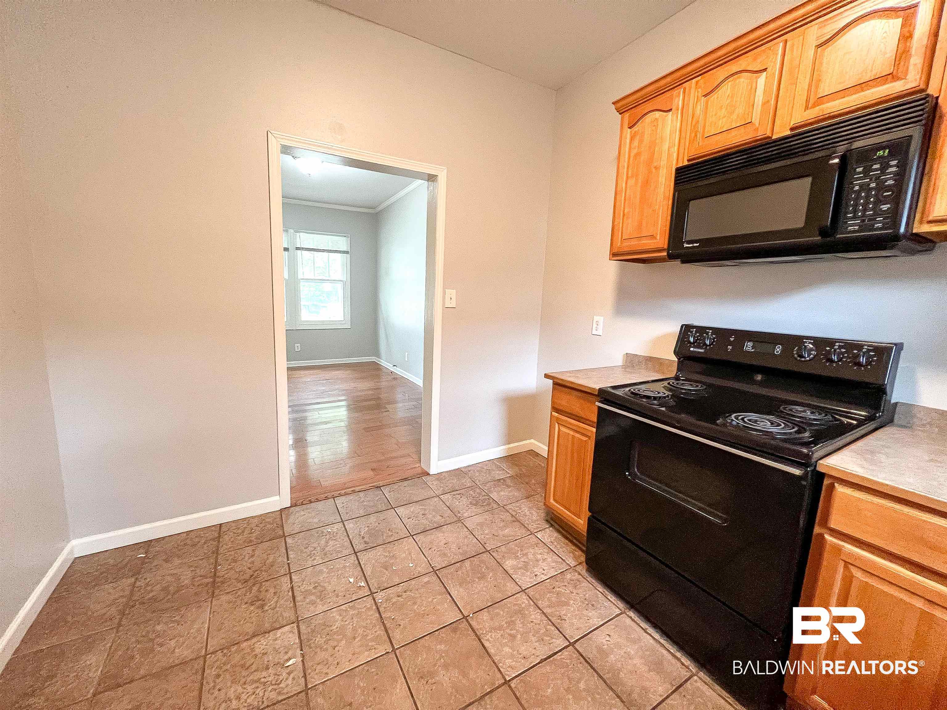 1164 Seneca Street Mobile, AL 36605 - Photo 11 of 22 Kitchen featuring light tile patterned floors, black appliances, light countertops, and baseboards