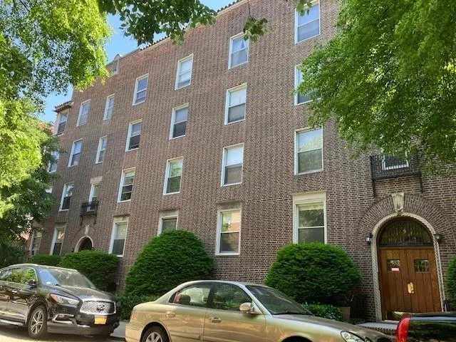 a view of a car parked in front of a brick house